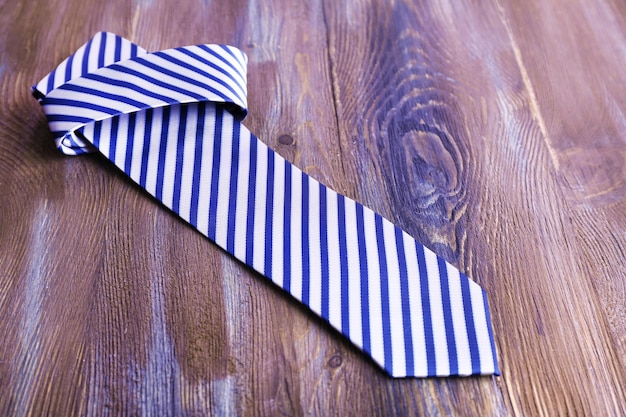 Striped necktie on wooden background