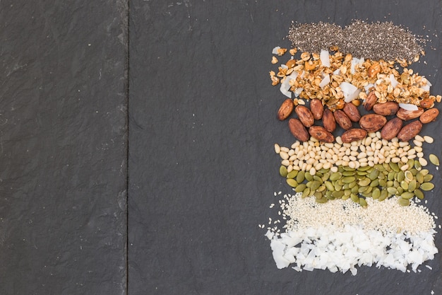 Striped rows of coconut flakes sesame seeds pumpkin seeds cacao beans granola and chia seeds