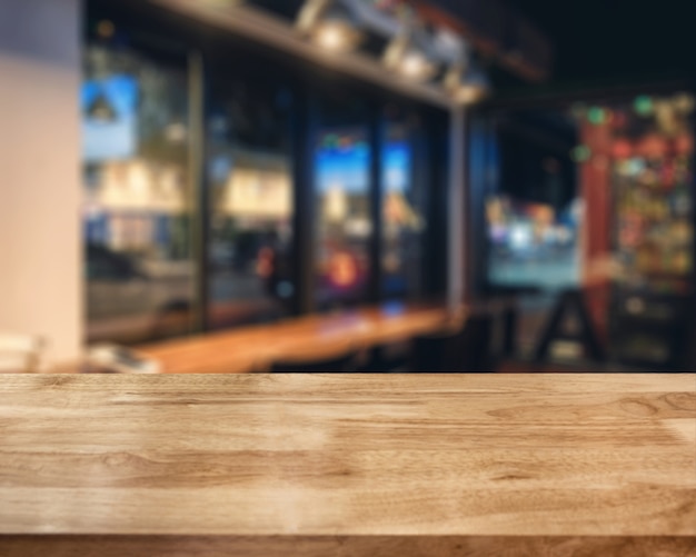 Striped wooden brown tabletop on glowing cafe at night