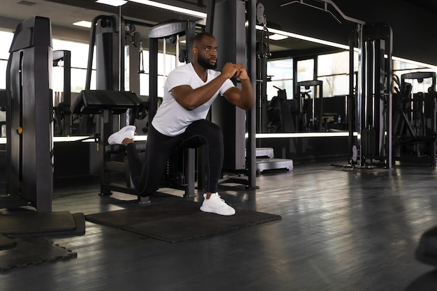 Strong african sportsman doing bulgarian lunges in a gym