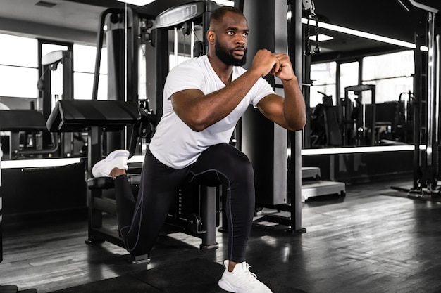 Strong african sportsman doing bulgarian lunges in a gym