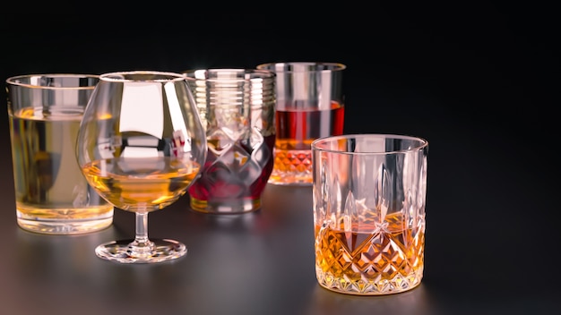 Strong alcoholic drinks, glasses on a dark background