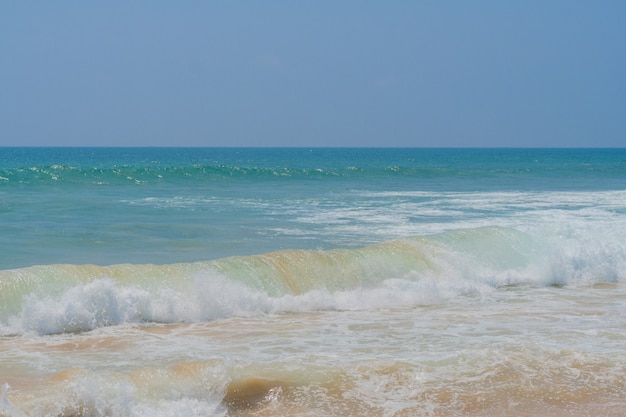 Strong coastal waves on the sandy shore of the ocean.