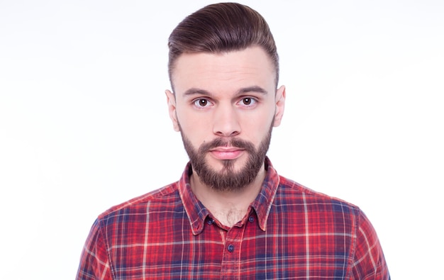 Strong confident handsome and bearded man in casual checkered shirt is posing isolated on white background with copy space for text and advertising