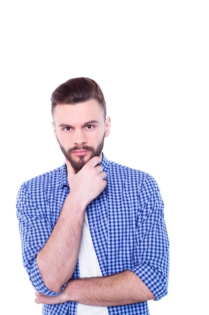 Strong confident handsome and bearded man in casual checkered shirt is posing isolated on white background with copy space for text and advertising