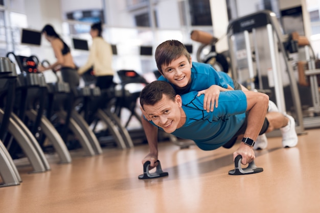 Strong dad wrung out with his son on his back.