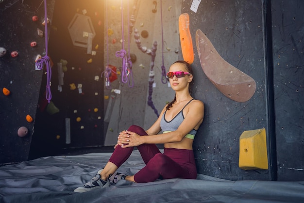 Photo a strong female climber against an artificial wall with colorful grips and ropes