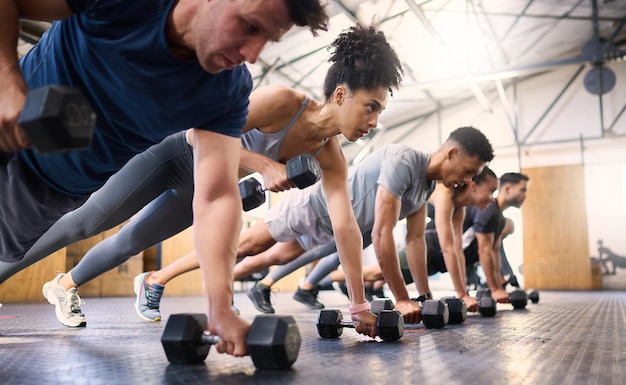 Strong fitness and gym people with dumbbell teamwork training or exercise community accountability and group Sports diversity friends on floor in pushup muscle workout power and wellness together