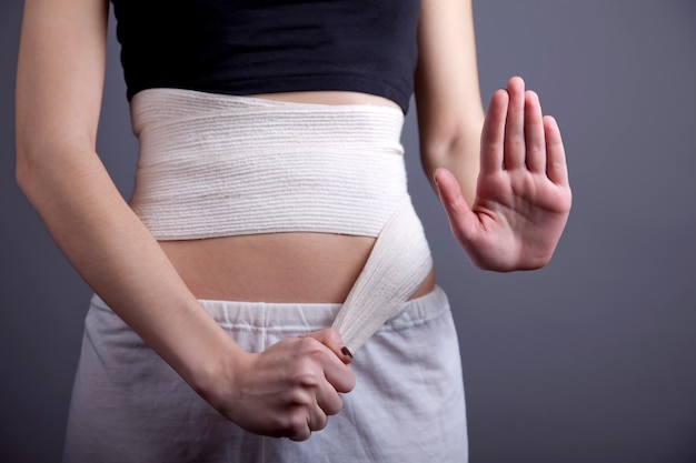 Strong girl's body with with elastic bandage on abs