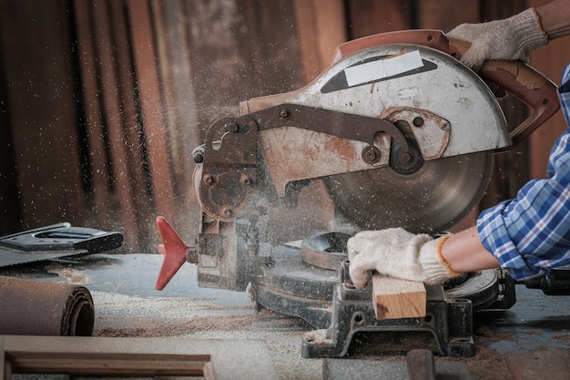 Strong man carpenter using table saw Industrial work concept