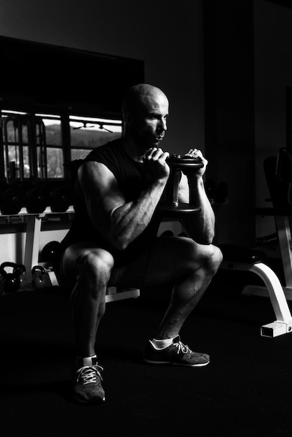 Strong Man In The Gym Exercising Hamstrings With Dumbbells  Muscular Athletic Bodybuilder Fitness Model Exercise