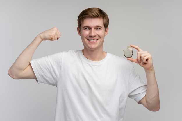 Strong man holding Implantable cardioverter defibrillator ICDs and showing biceps