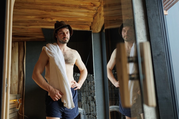 Strong man standing in sauna after spa treatments