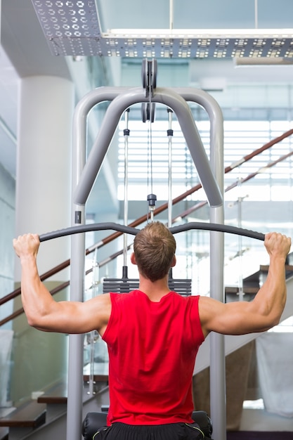 Strong man using weights machine for arms