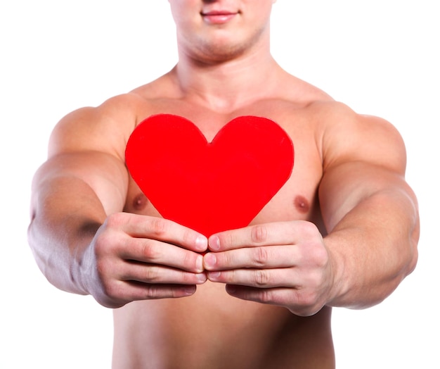 Strong muscular man holding red valentine's heart at white background