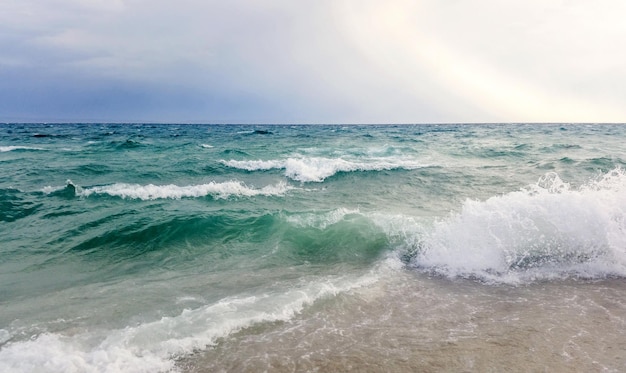 Strong waves crash over the beach Beautiful seascape.