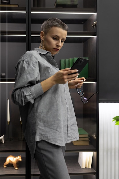 Strong woman on in a gray interior with a phone in her hands