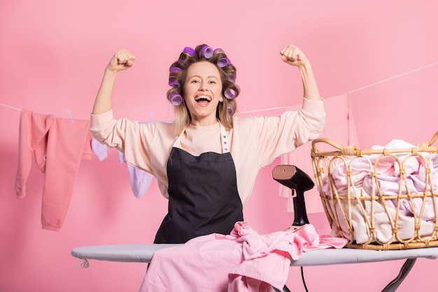 A strong woman working at household chores raises her arms up exposing her biceps