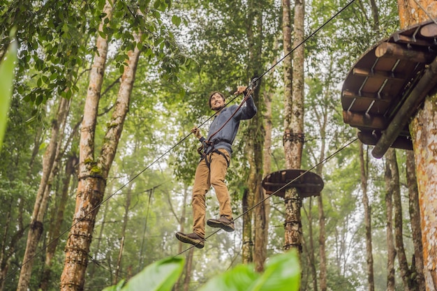 Strong young men in a rope park on the wood background