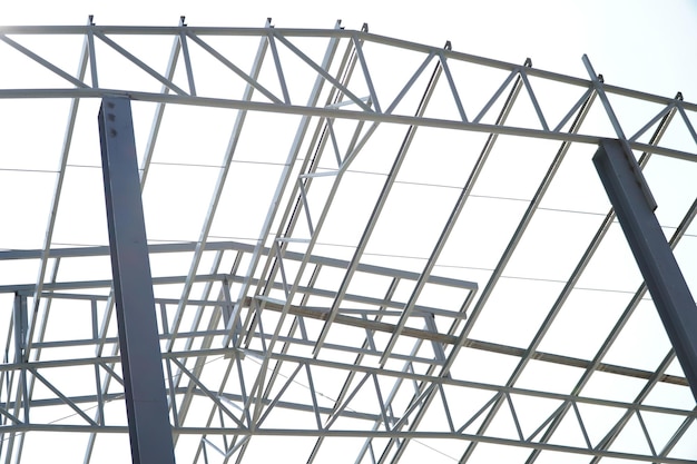 Structure of steel roof frame for building construction on sky background