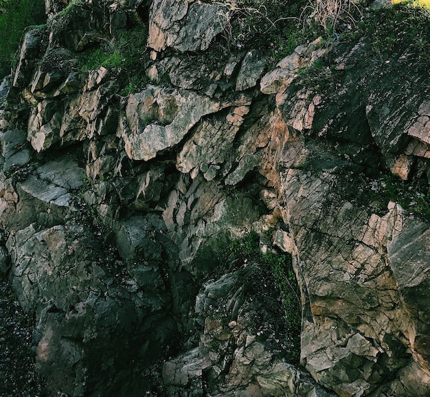 Structure of the surface of the mountains. Daylight, sunny day, nature mountains. Rock structure. Stone. Cracks. Texture