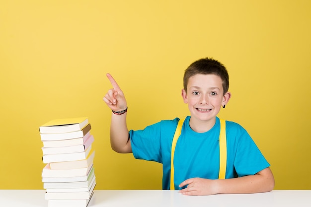 Student boy pointing at yellow copy space