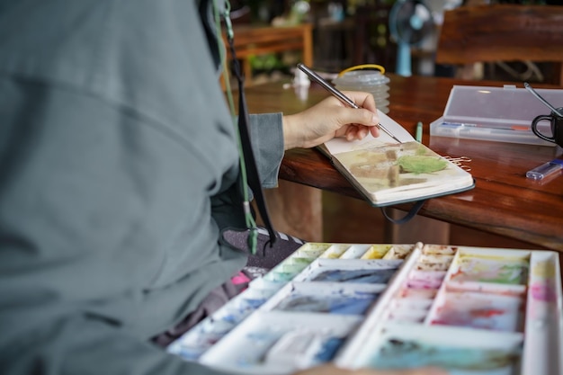 Student in classes at art studio Hand holding artist brush mix color oil painting on palette