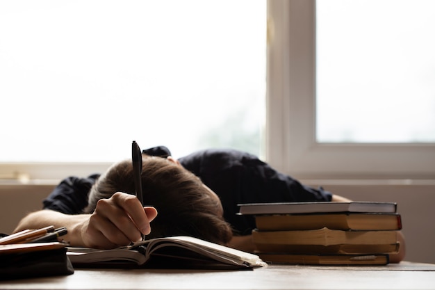 Student fell asleep for homework on sunny background