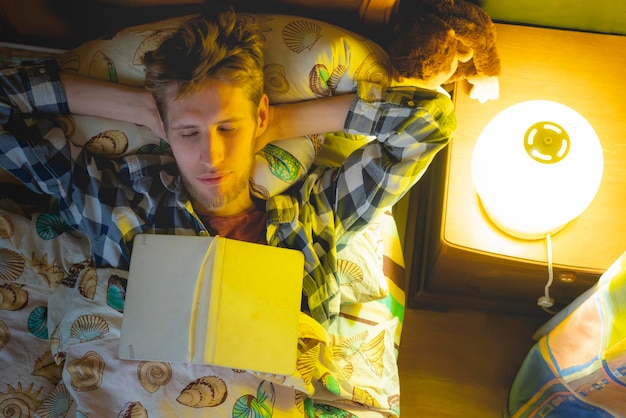 Student fell asleep while reading book in bed b