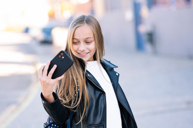 Student girl on the way to school using a smartphone