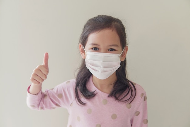 Student girl wearing mask and giving thumb up