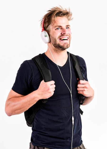 Student handsome guy listening music. Modern people concept. Man tousled hairstyle wear plastic earphones gadget. Enjoy music everywhere you go. Download music application. Youth music taste.