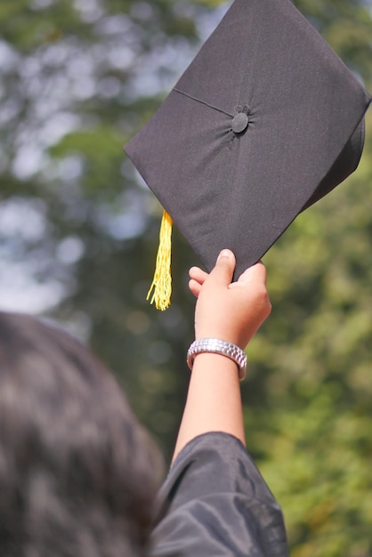 Student hold hats in hand during commencement success on yellow background