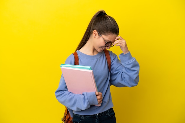 Student kid woman over isolated yellow surface laughing