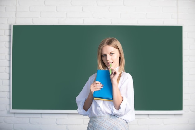 Student preparing exam and learning lessons in school classroom female student taking notes from a b