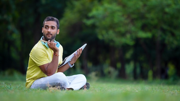 Student sitting on the grass thinking something