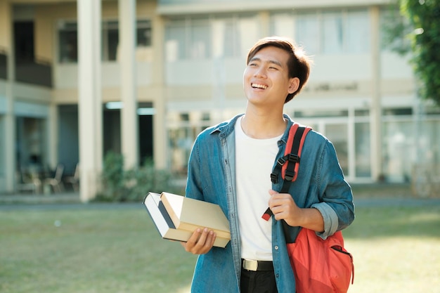 Student standing outdoor and holding books