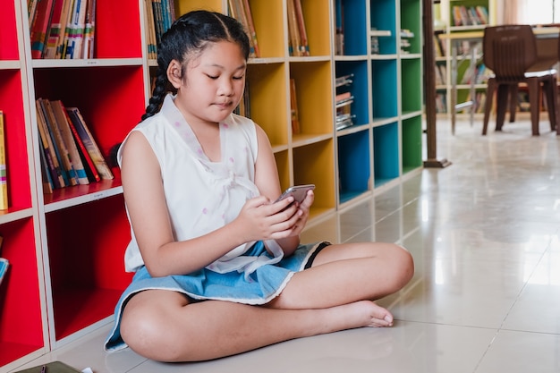 Student teenager girl using smart phone for education in school.