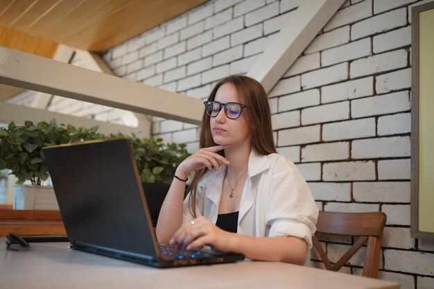 Student Texting Message in laptop at cafe