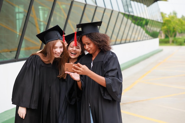 Student wearing gown and making photo by smartphone graduating Happy graduate success and celebration Congratulation