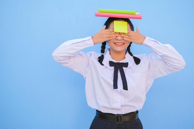 Student with book and small note paper on blue background