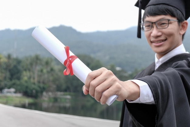 Student with congratulations graduates wearing a graduation gown of university