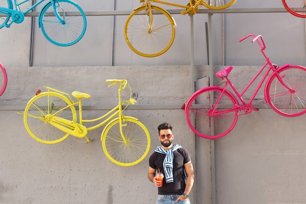 Student with a stylish mustache and a beard with juice in his hands