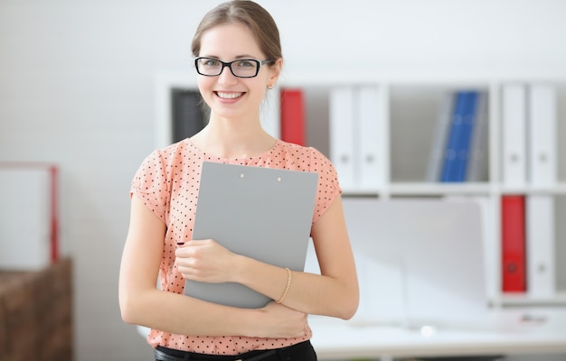 Student woman holding a tablet for notes in the hands in the audience