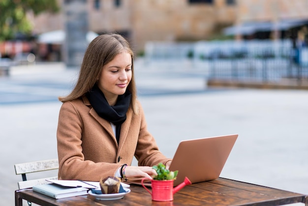 Student works sitting at a bar table with her laptop young business woman in remote working study activities and entrepreneurship in outdoor