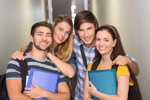 Students holding folders at college corridor