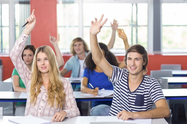 Students raising hands in classroom