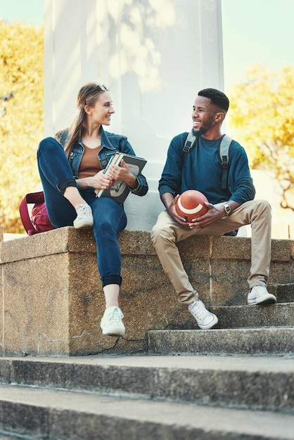 Students relax and friends in college park for study education and happy learning University woman with books and african sports man or university student together summer outdoor for happiness