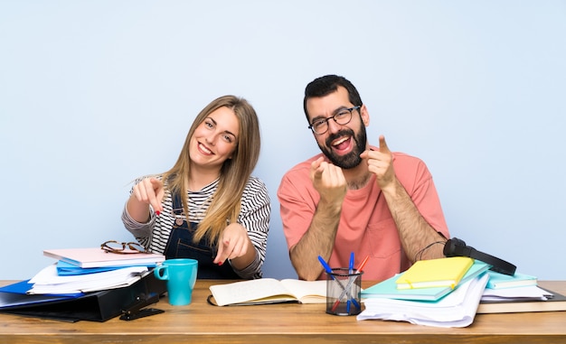 Students with many books points finger at you while smiling