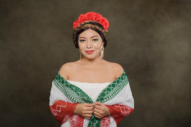 Studio female portrait of Mexican woman with scarf with the colors of the Mexican flag.